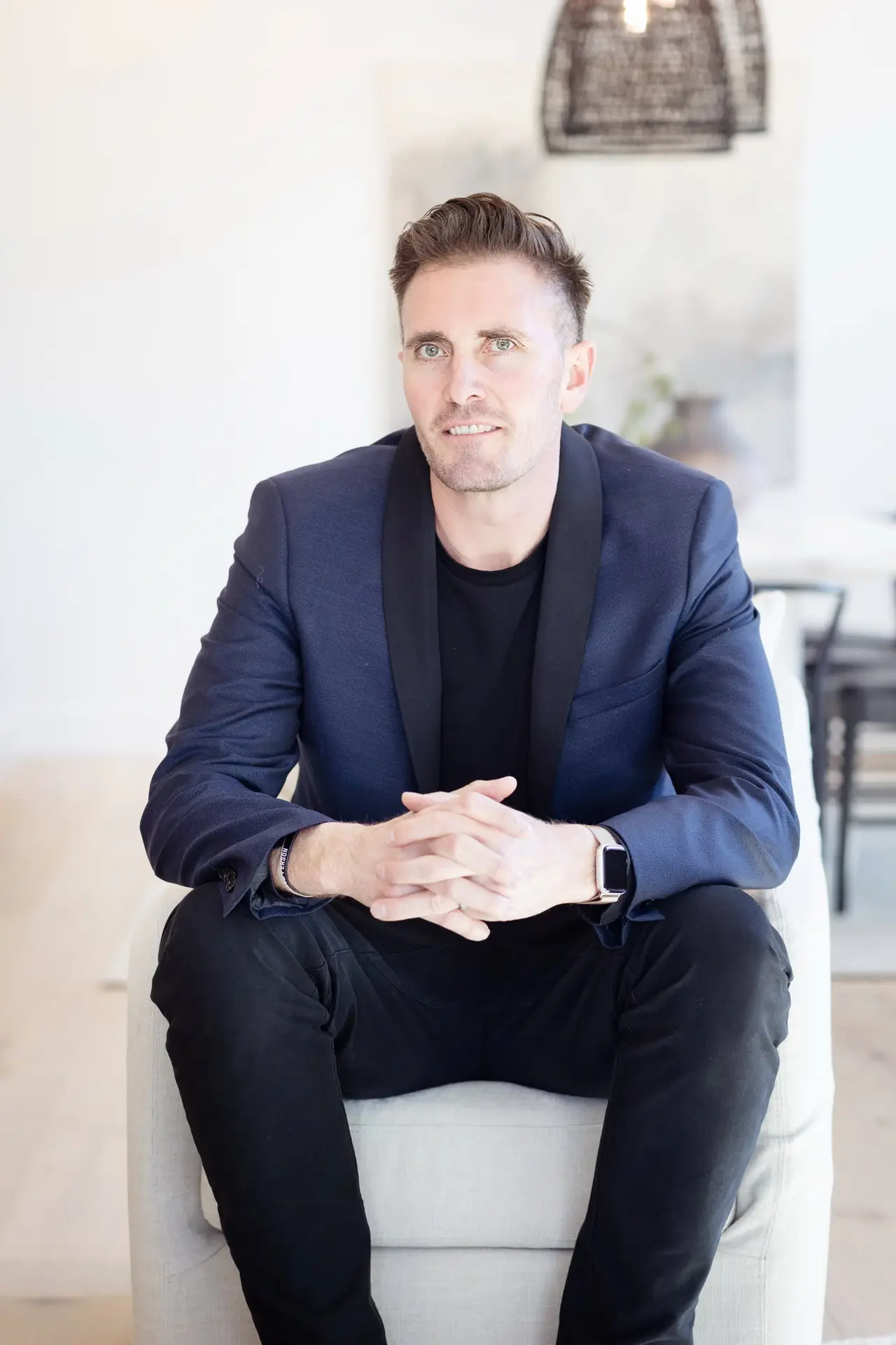 Nicholas Quenzer seated in a bright, modern living room