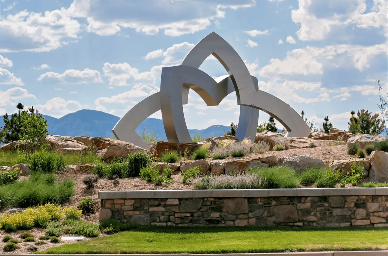 Sculpture and landscaped entry at Sterling Ranch with the foothills behind